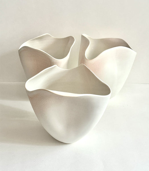 Ensemble de 3 vases tournés en porcelaine et travaillés à la main pour s formes organiques inspirés de la nature, émaillés en blanc mat avec des effets de couleurs rose poudré en dégradé